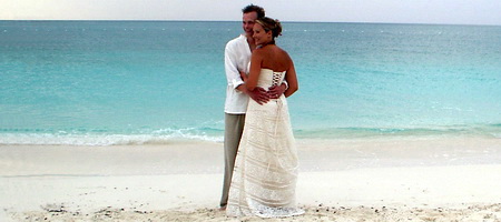 The bride and groom pose for photos on Grace Bay beach