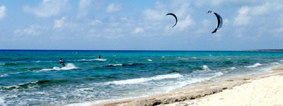 Kiteboarders flying high and doing flips and jumps entertained us on the beach today