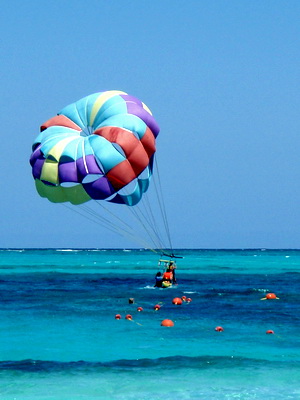 Parasailers being dipped in and out of the water