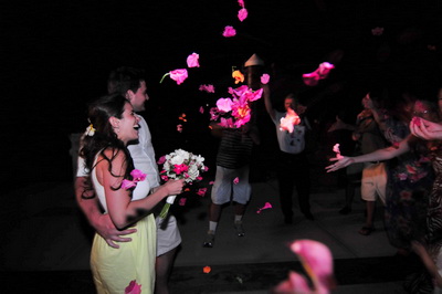 Arriving back on shore, bouganvillea flowers are tossed at the wedding couple