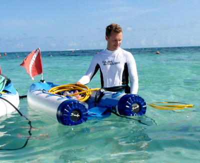 Sheldon holds onto the raft that carries the air tanks and floats above the divers