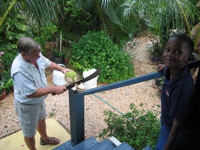 Barry uses his machete to cut away the fibrous husk surrounding the coconut.