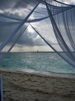 The other day a white, airy wedding canopy was erected and readied for a sunset beach wedding. A hobie cat was sailing by almost on the horizon as I took this photo.